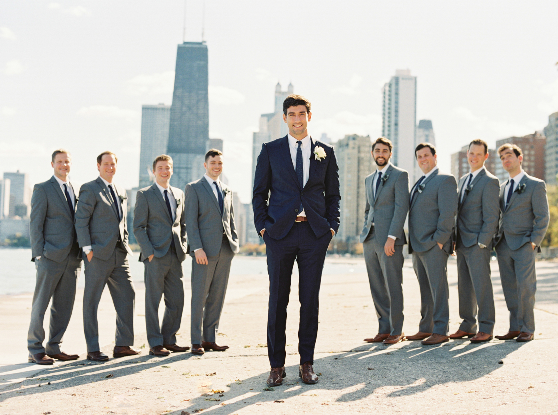 groom and groomsmen pose with Chicago skyline photo by Chicago Wedding Photographer Kati Rosado