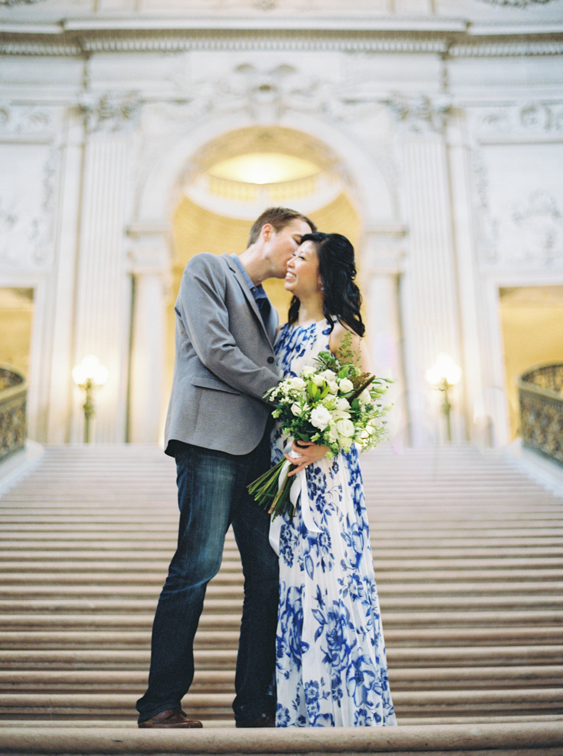 engaged couple kissing on grand staircase at San Francisco City Hall Engagement Session