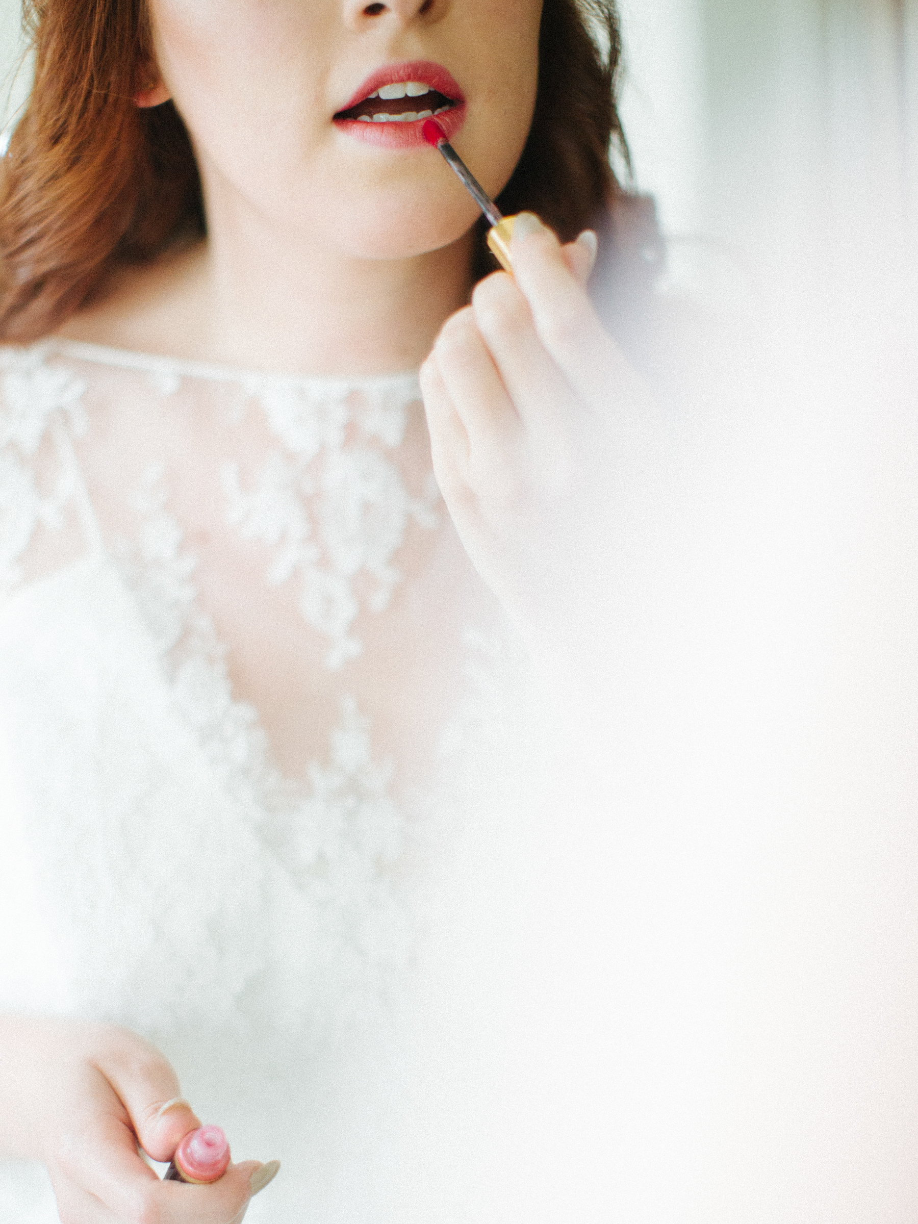 bride putting on lipstick at Iceland Wedding At Hotel Budir & the Black Church