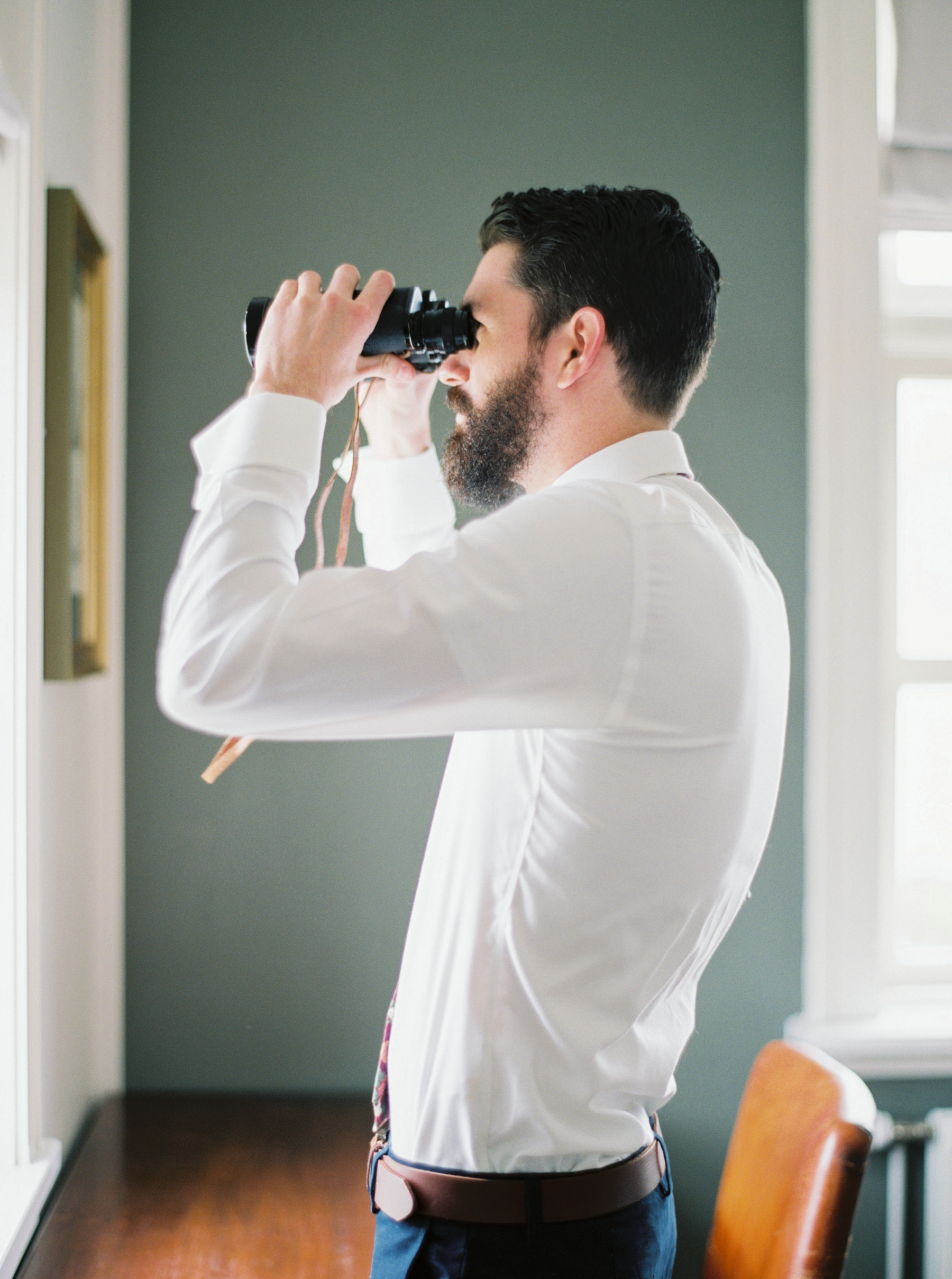 groom with binoculars looking at Iceland 