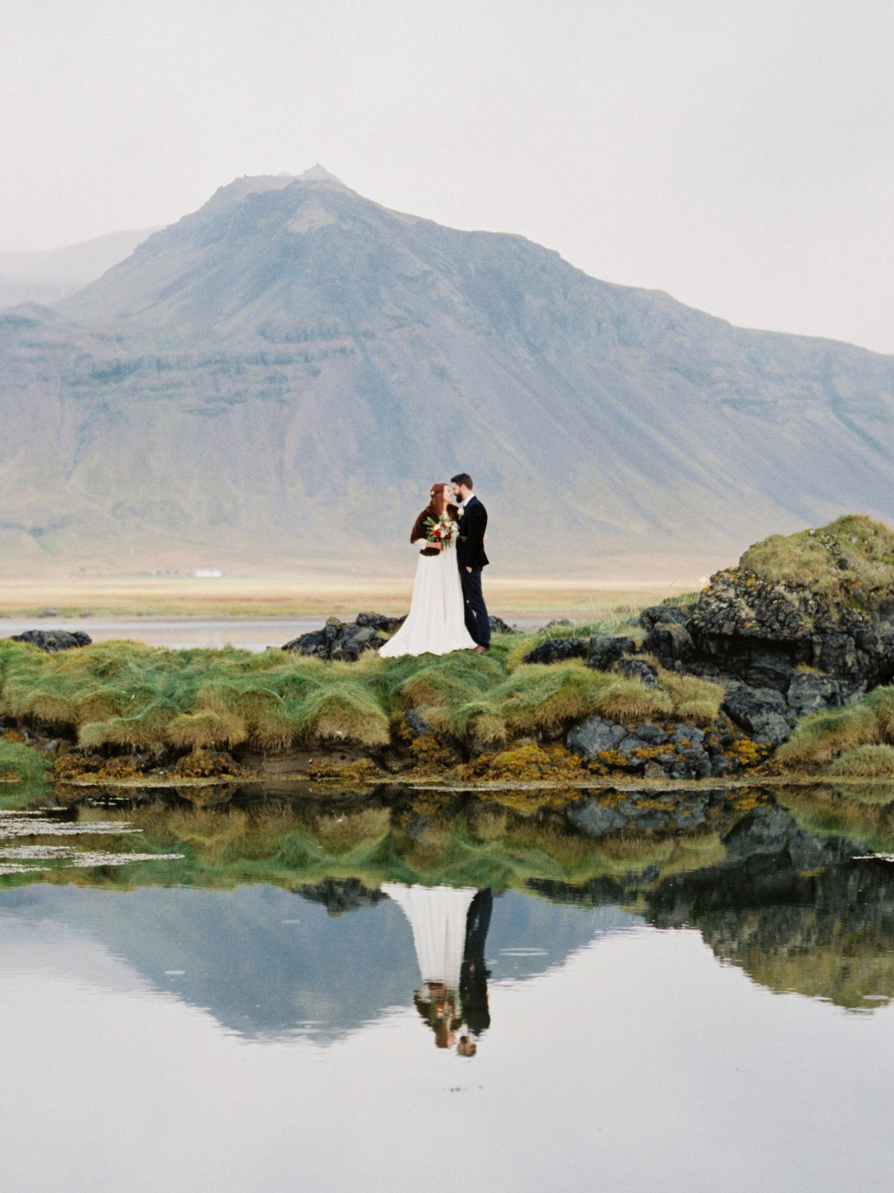 bride and groom photograph in Iceland with mirror image in lake at Iceland Wedding At Hotel Budir & the Black Church