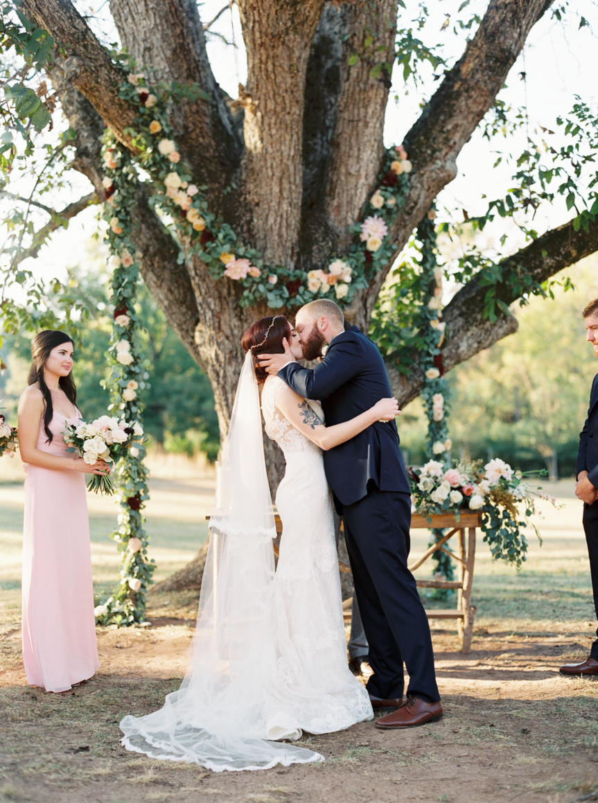 newlyweds kiss at outdoor floral altar in Newnan Georgia