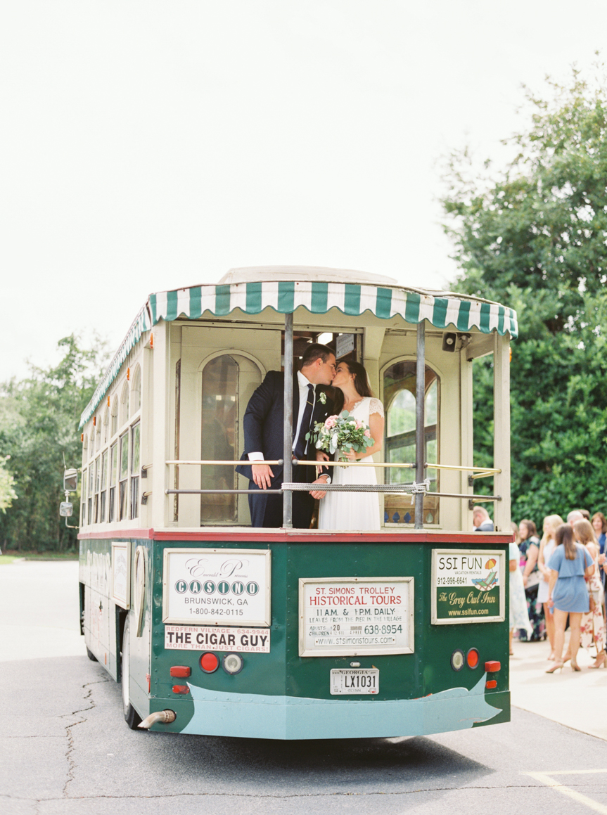 Saint Simon Island Wedding Photography bride & groom kissing on trolley