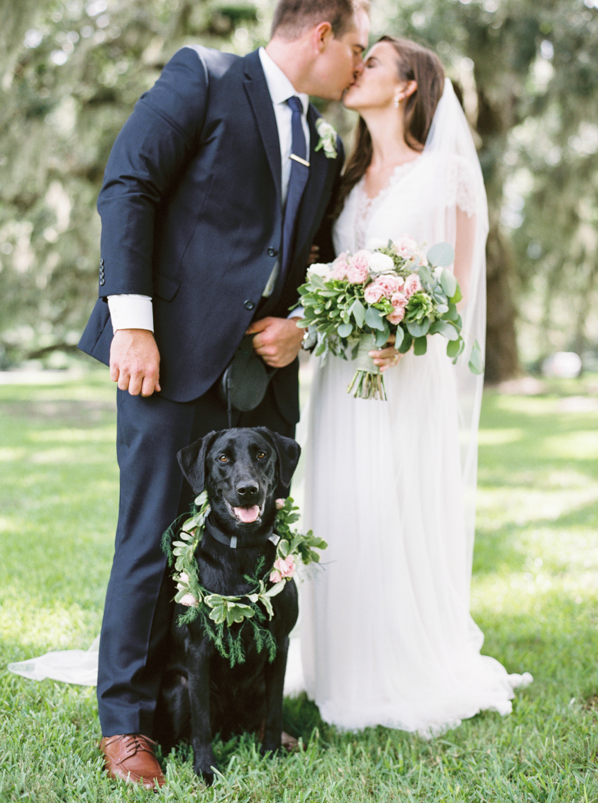 Saint Simon Island Wedding Photography bride and groom kissing with dog sitting in front of them